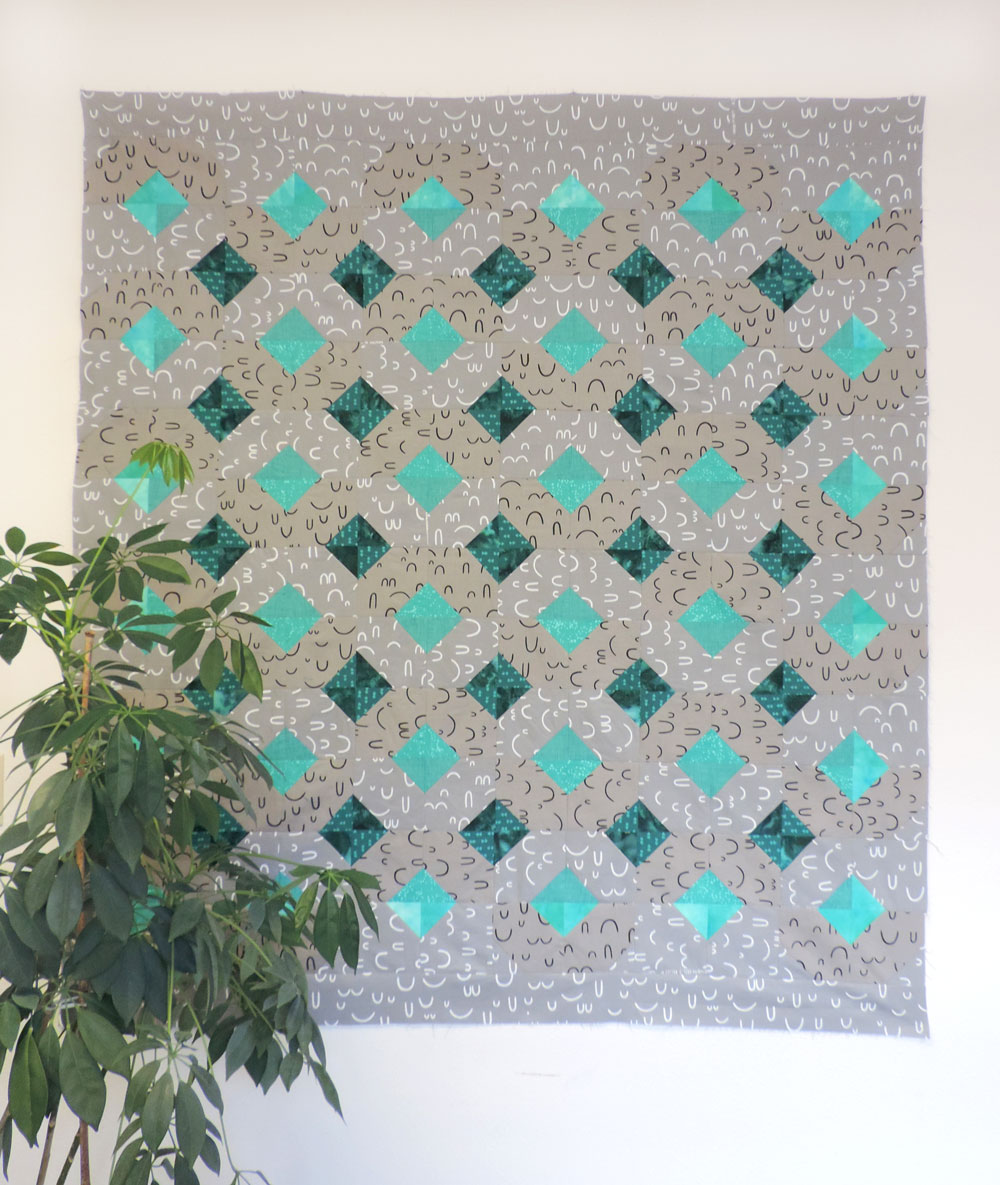 This gray and teal Arroyo quilt is subtle and shows how different the Glitter and Glow pattern can look based on the fabrics you choose.