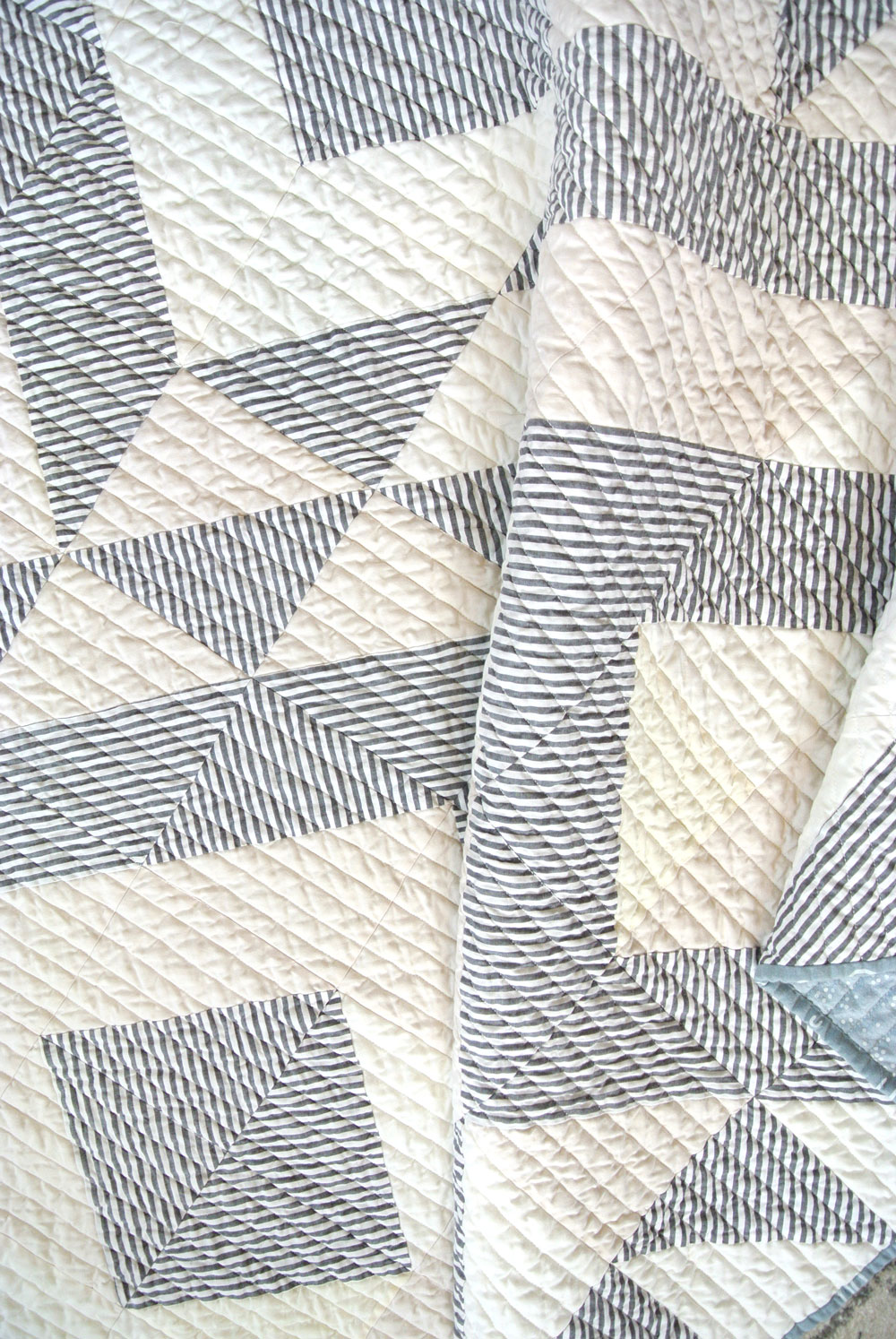 The crinkled straight line quilting on this Triangle Jitters quilt shows what fabric looks like after it is washed