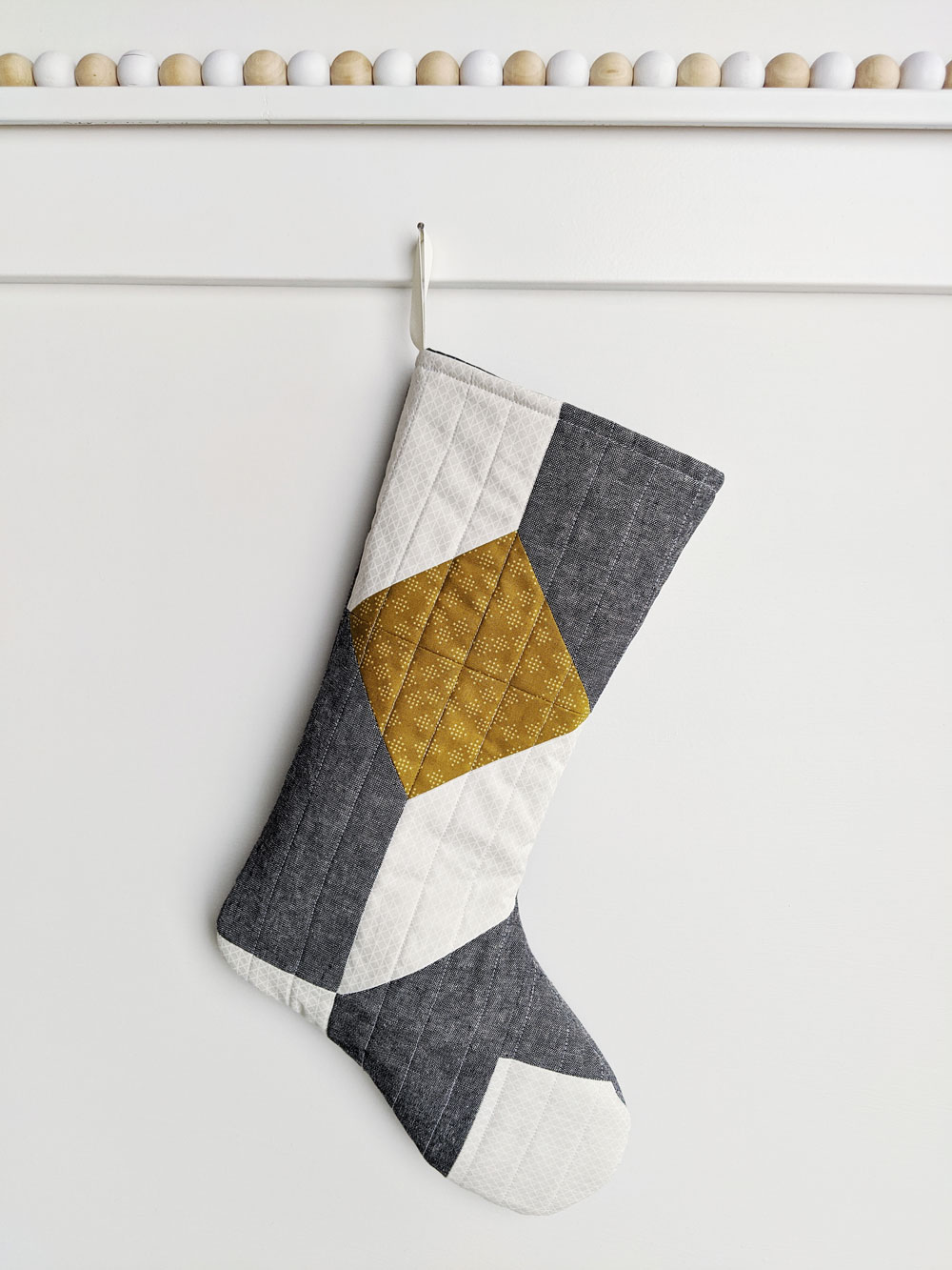 A free quilted Christmas stocking pattern right in time for the holidays! Sew a simple, modern stocking with this step by step tutorial. suzyquilts.com #DIYstocking #quilttutorial