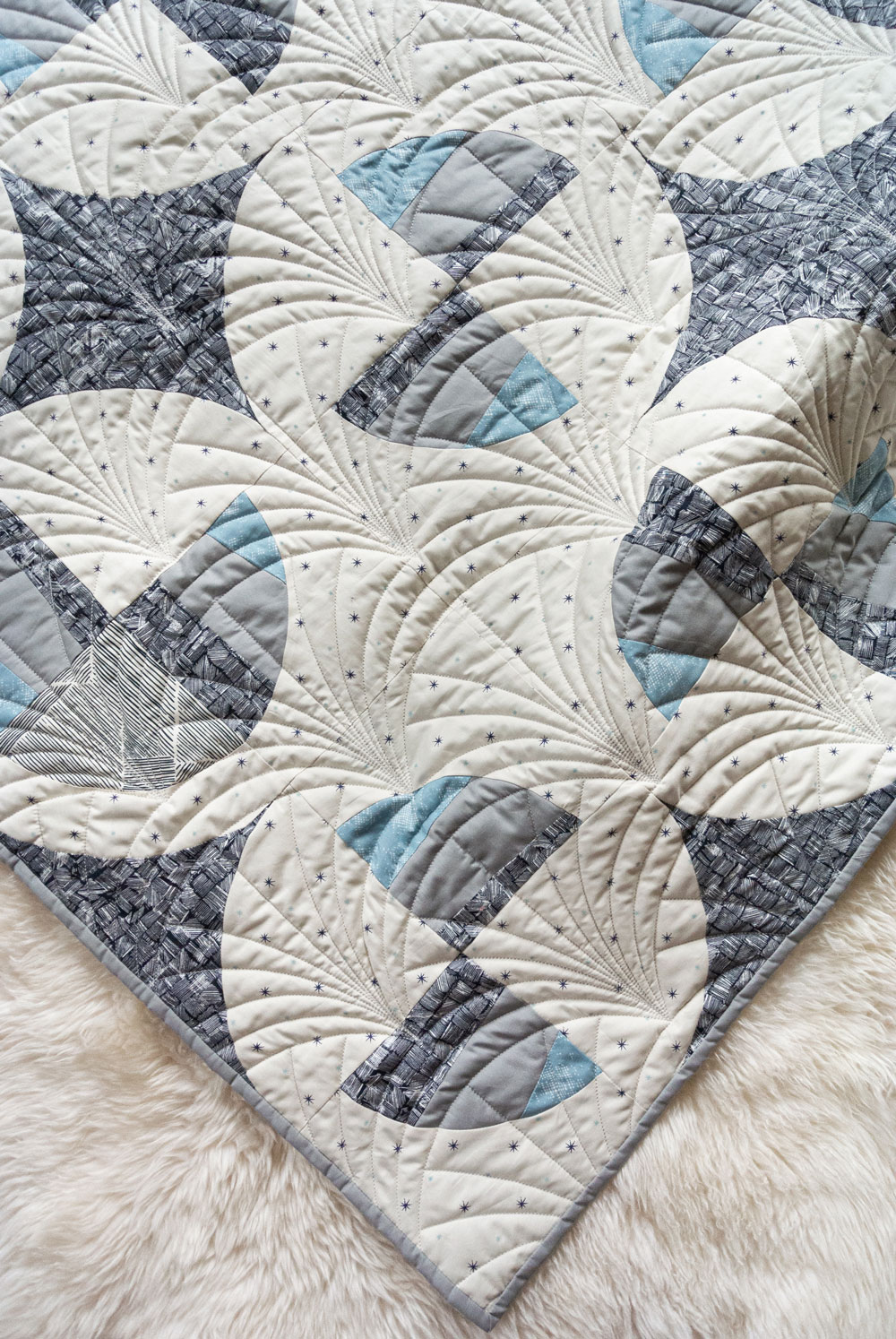 This Great Gatsby inspired Modern Fans quilt kit uses icy blues, grays and metallic silver fabric to bring elegance and pizzazz to a cozy quilt. suzyquilts.com #artdeco