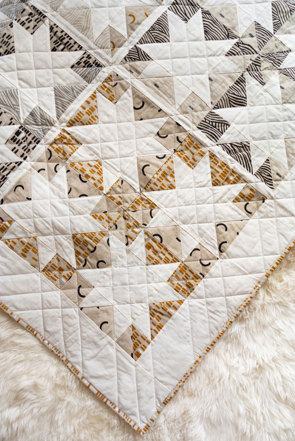 Make a sophisticated, neutral quilt using the Stars Hollow quilt pattern. This is a classic quilt pattern, but with a modern twist. The design plays on negative space to create traditional sawtooth star quilt blocks. suzyquilts.com #linen #quiltpattern