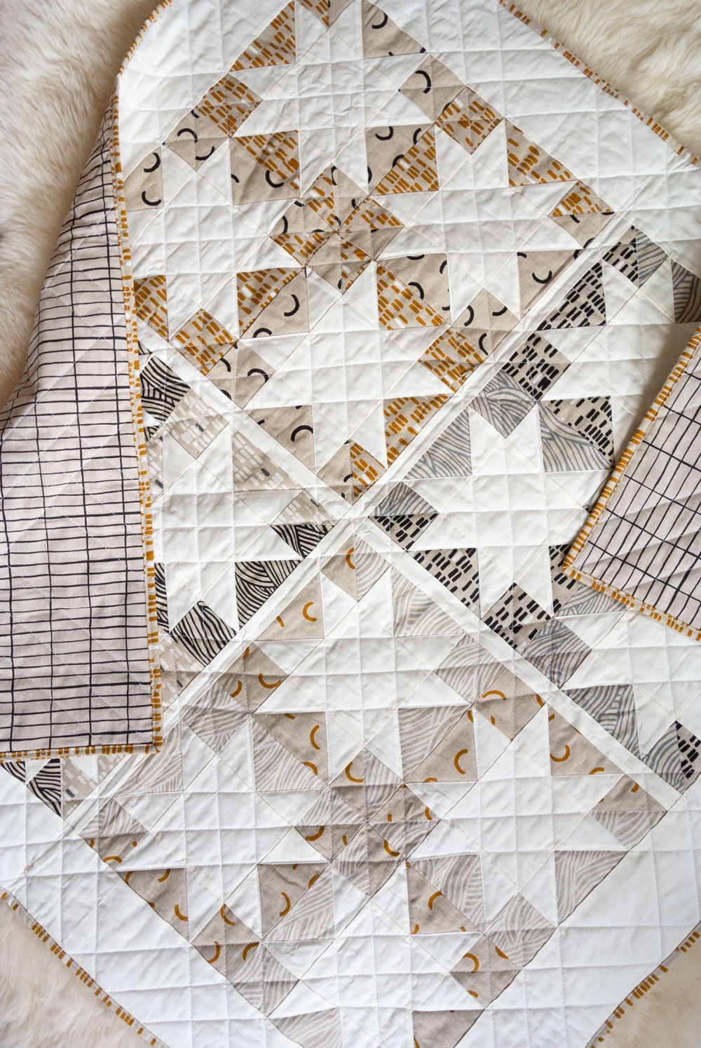 Make a sophisticated, neutral quilt using the Stars Hollow quilt pattern. This is a classic quilt pattern, but with a modern twist. The design plays on negative space to create traditional sawtooth star quilt blocks. suzyquilts.com #linen #quilt