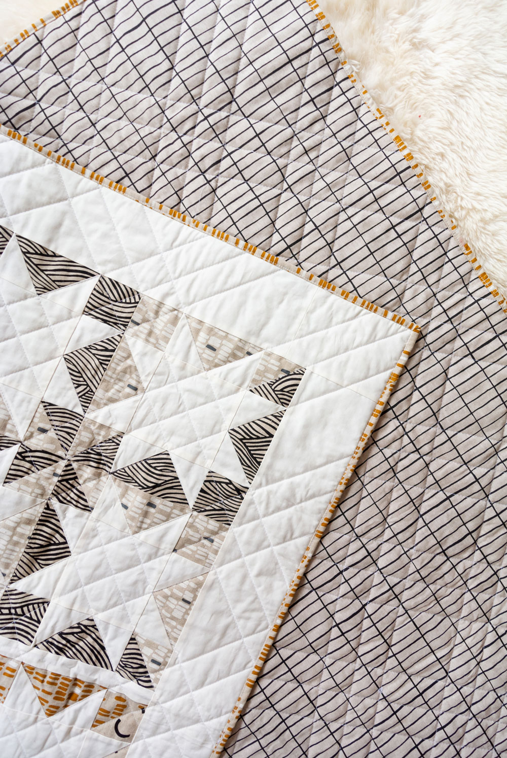 Make a sophisticated, neutral quilt using the Stars Hollow quilt pattern. This is a classic quilt pattern, but with a modern twist. The design plays on negative space to create traditional sawtooth star quilt blocks. suzyquilts.com #linen #quiltpattern