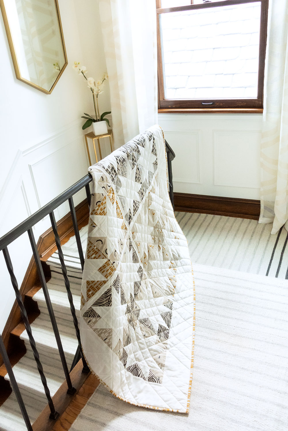 Make a sophisticated, neutral quilt using the Stars Hollow quilt pattern. This is a classic quilt pattern, but with a modern twist. The design plays on negative space to create traditional sawtooth star quilt blocks. suzyquilts.com #homedecor #quiltpattern