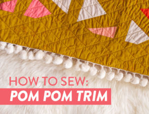 This tutorial will show you step by step how to sew pom pom trim to a quilt. Make your next quilt extra special with this easy sewing tutorial | suzyquilts.com #sewingtutorial #pompoms