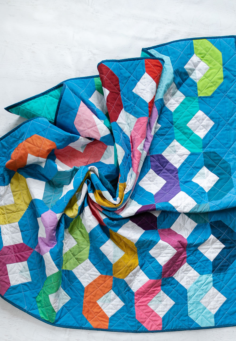 Make a Rainbow Quilt using this simple alteration to the Glitter & Glow quilt pattern. This is fat quarter friendly and great for newbie quilters and beginners. suzyquilts.com #rainbowquilt #rainbowbabyquilt