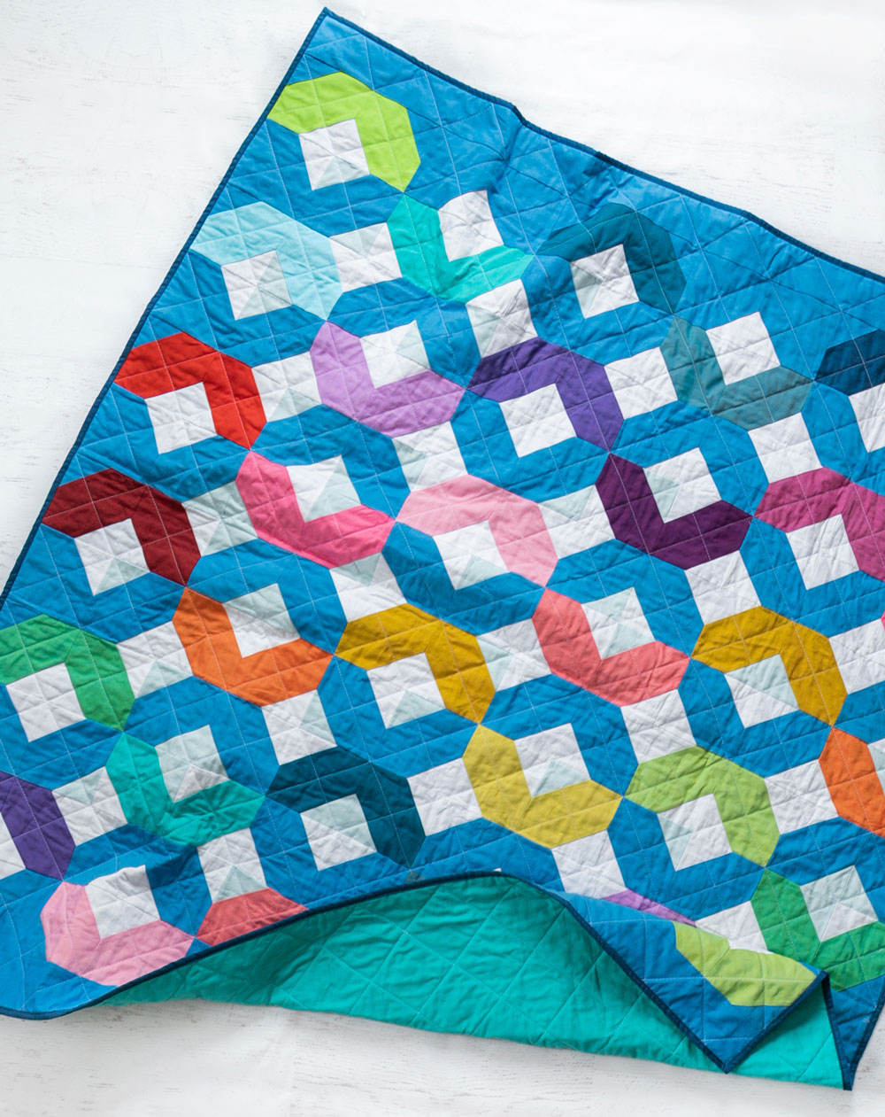 Make a Rainbow Quilt using this simple alteration to the Glitter & Glow quilt pattern. This is fat quarter friendly and great for newbie quilters and beginners. suzyquilts.com #rainbowquilt