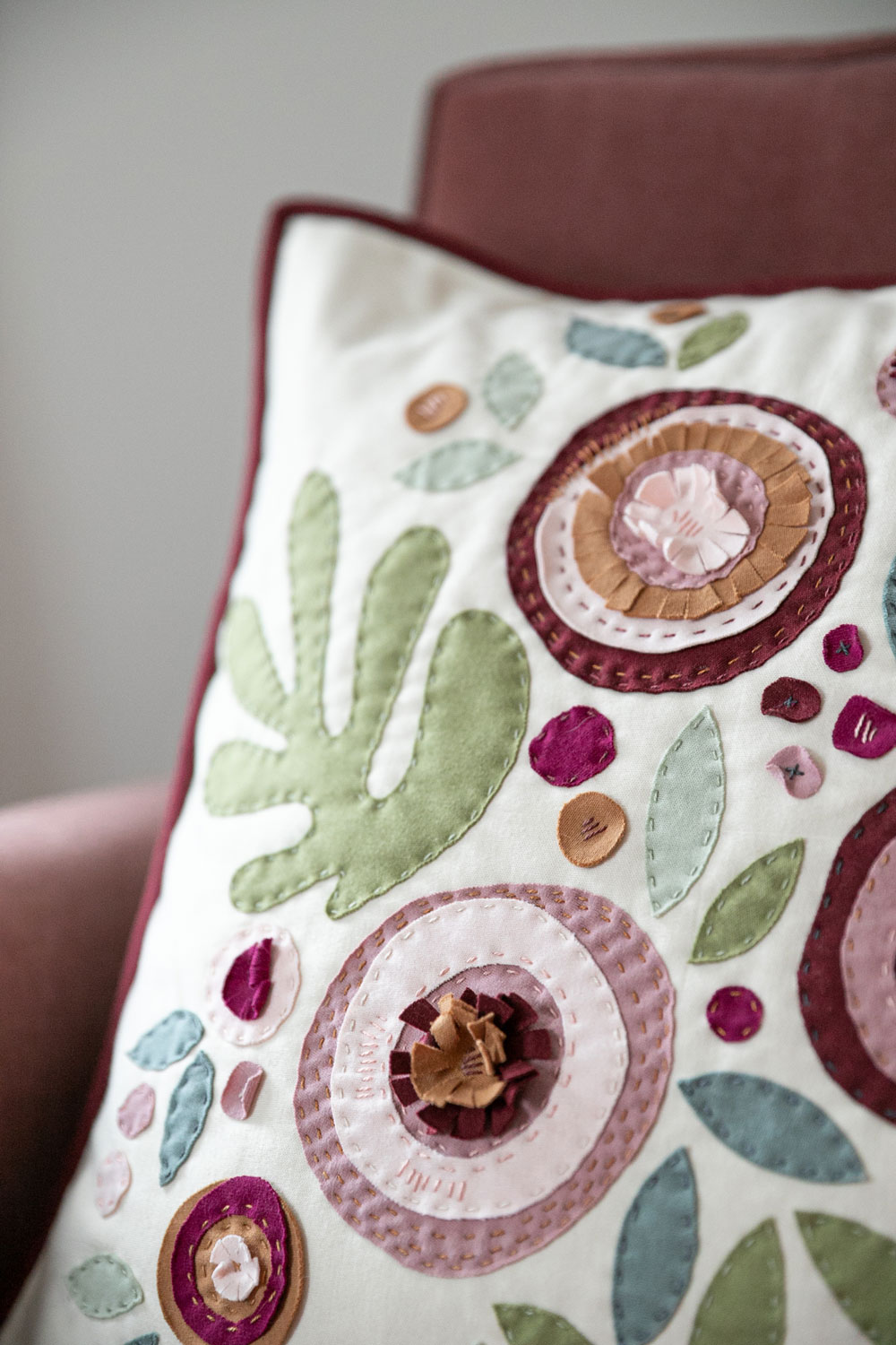 Make a modern appliqué pillow with knits! By using templates from the Bohemian Garden quilt pattern, you can create a buttery soft handmade pillow. suzyquilts.com #applique