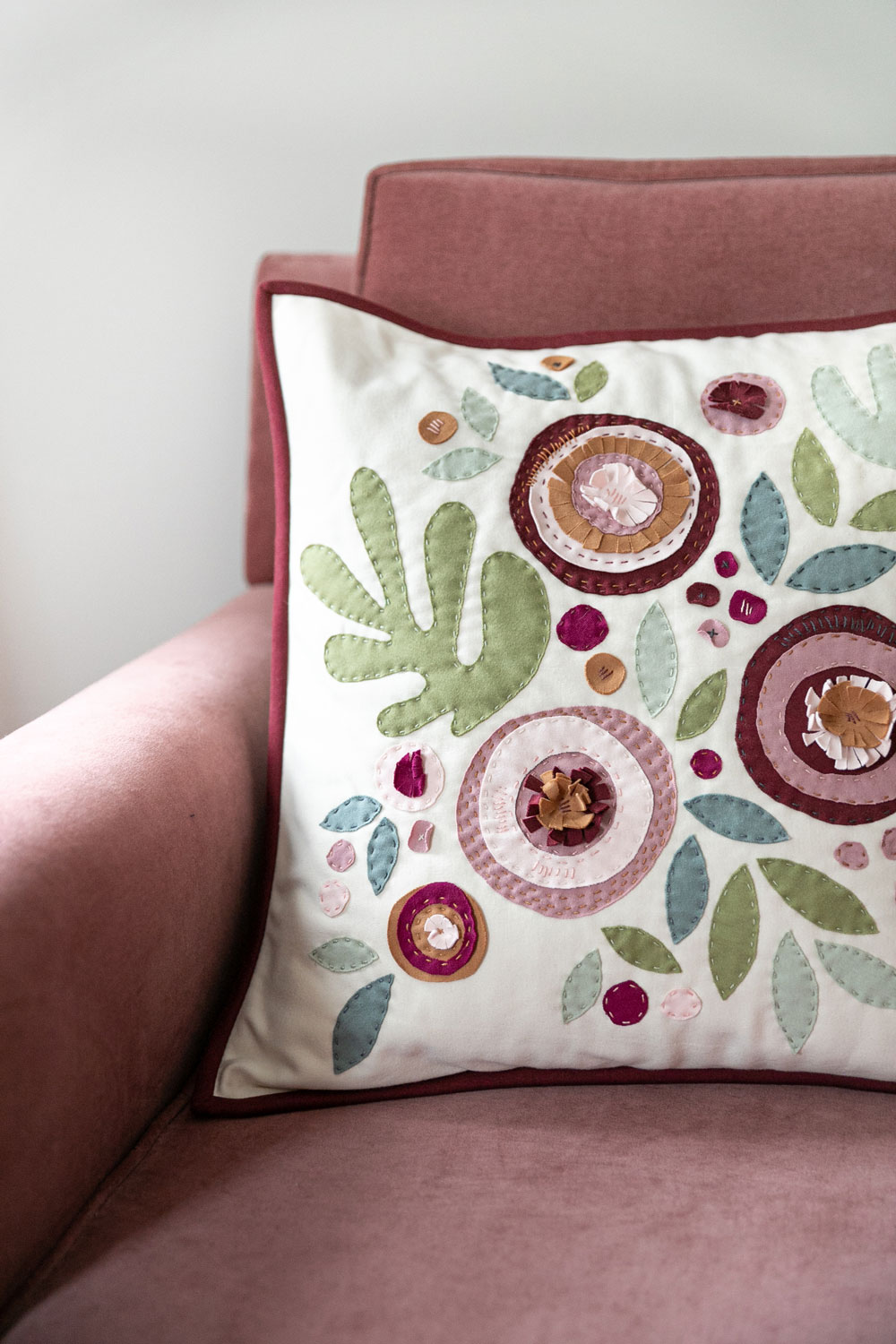 Make a modern appliqué pillow with knits! By using templates from the Bohemian Garden quilt pattern, you can create a buttery soft handmade pillow. suzyquilts.com #quiltedpillow