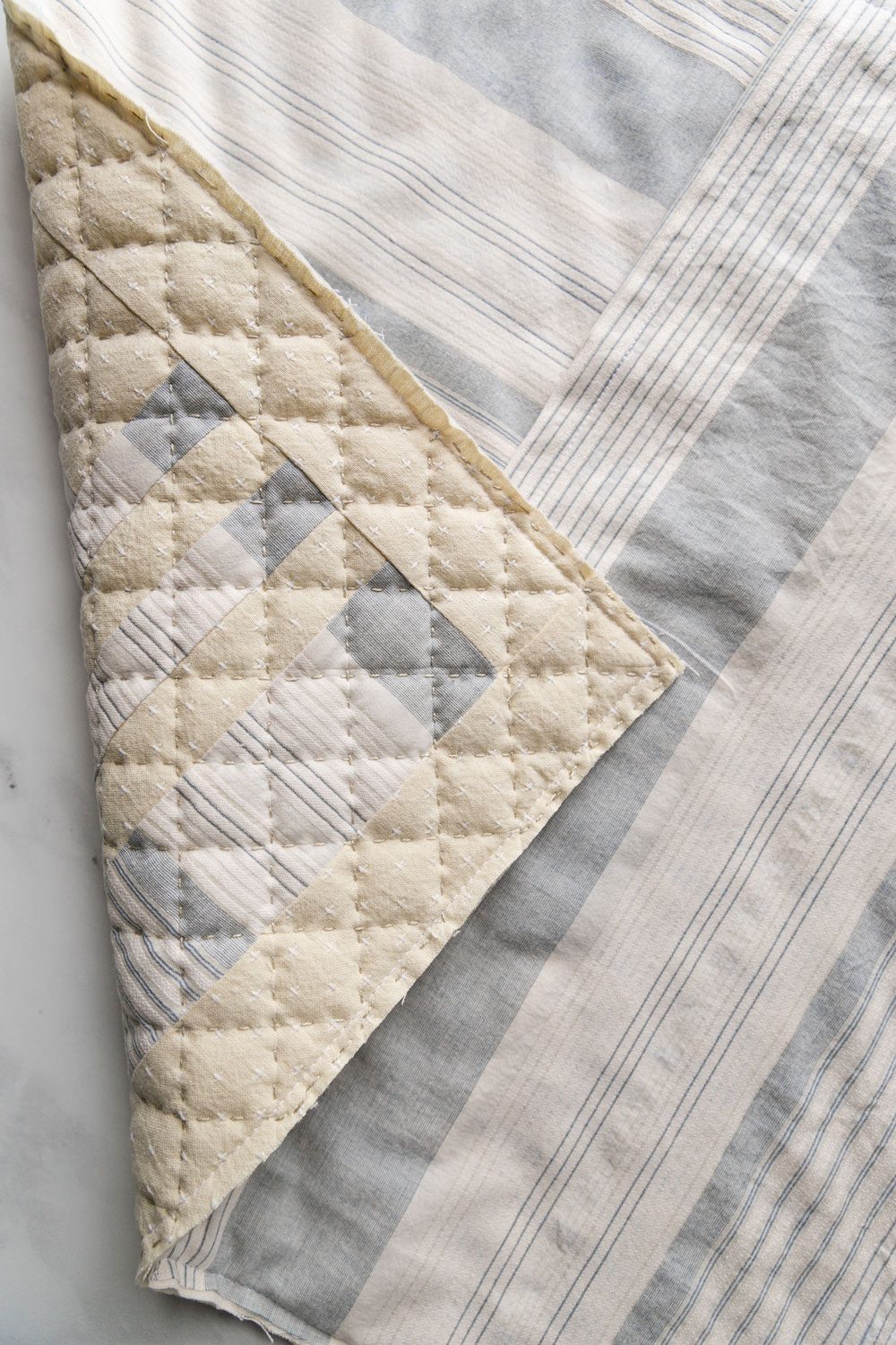 In this easy, beginner friendly quilting tutorial you will make a beautiful pillow with a simple envelope pillow cover. At the end there will be an option to finish the quilted pillow with binding | suzyquilts.com #quiltedpillow