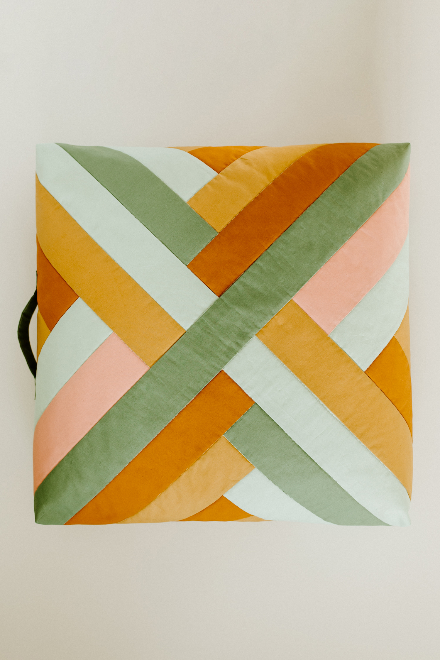 This quilted floor pillow tutorial walks you through step-by-step instructions to sew a floor pillow using the Maypole wall hanging pattern. suzyquilts.com #sewingtutorial #sewingdiy