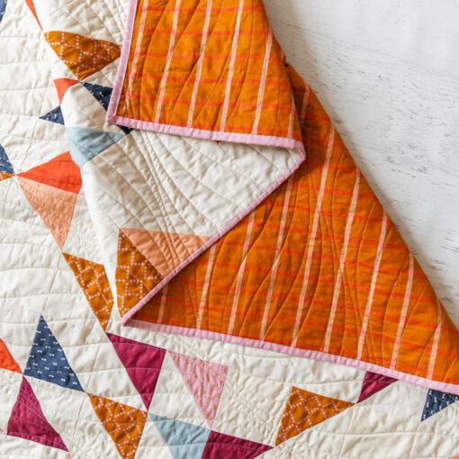 Summer Haze is a modern fat quarter quilt pattern that is beginner friendly and a great quilt pattern for using scrap fabric. Use the basic half square triangle to make this quilt! suzyquilts.com #quiltpattern #modernquilt