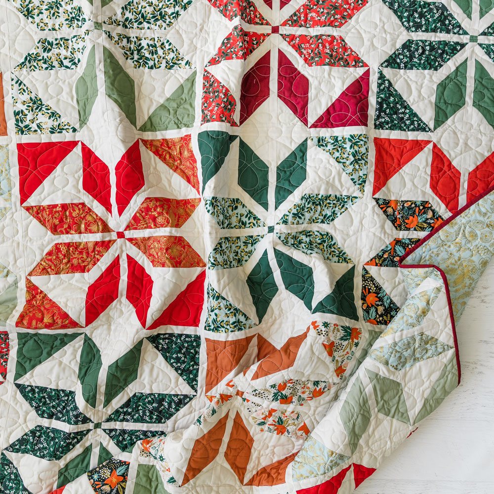 A festive Holiday Party quilt kit for a 77" x 77" throw quilt. This kit includes 16 fat quarters and background fabric to make a finished top. suzyquilts.com