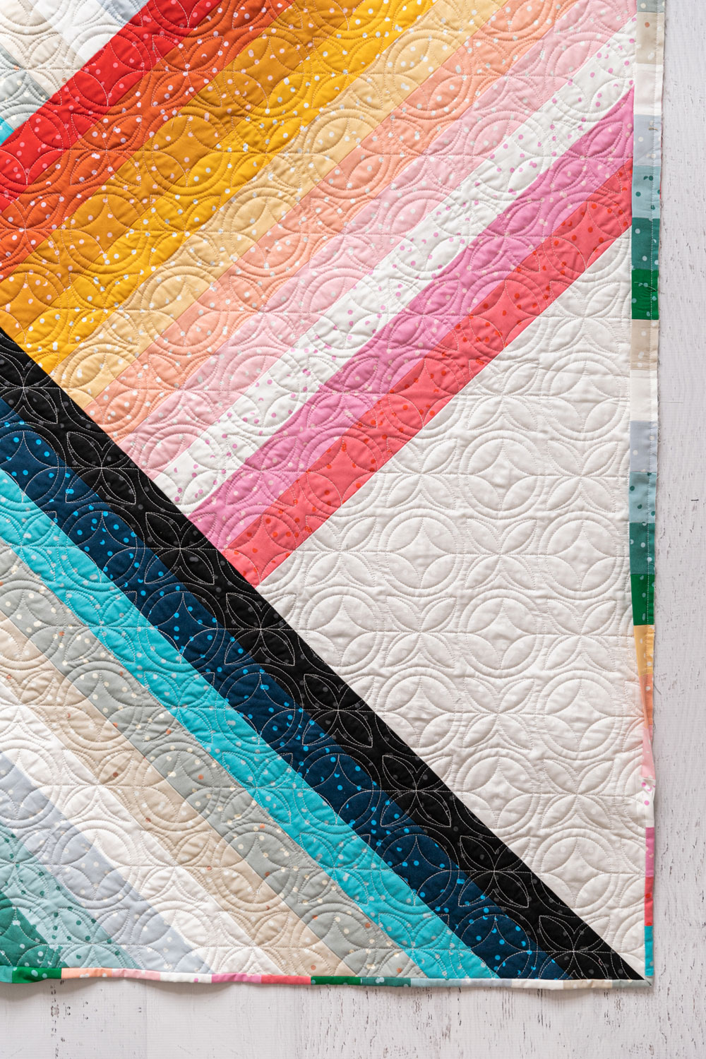 Use the trimmed scraps from the Adventureland quilt pattern to make a fun pieced binding! This is a fantastic way to maximize your fabric. suzyquilts.com #quilttutorial