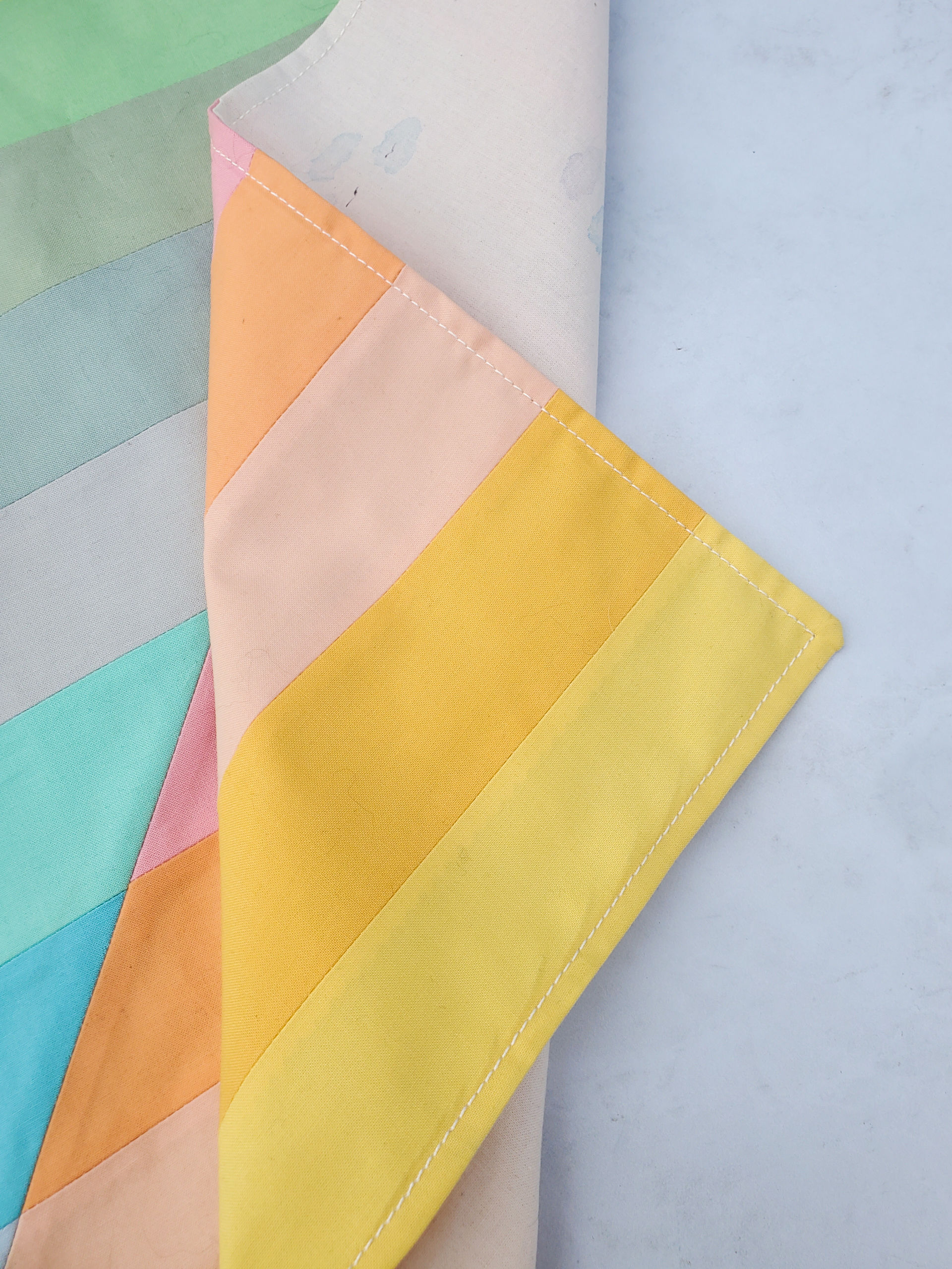 How to make a patchwork bandana with the leftover scraps from the Adventureland quilt pattern. This bandana tutorial is fast and easy! suzyquilts.com #bandana #sewingtutorial
