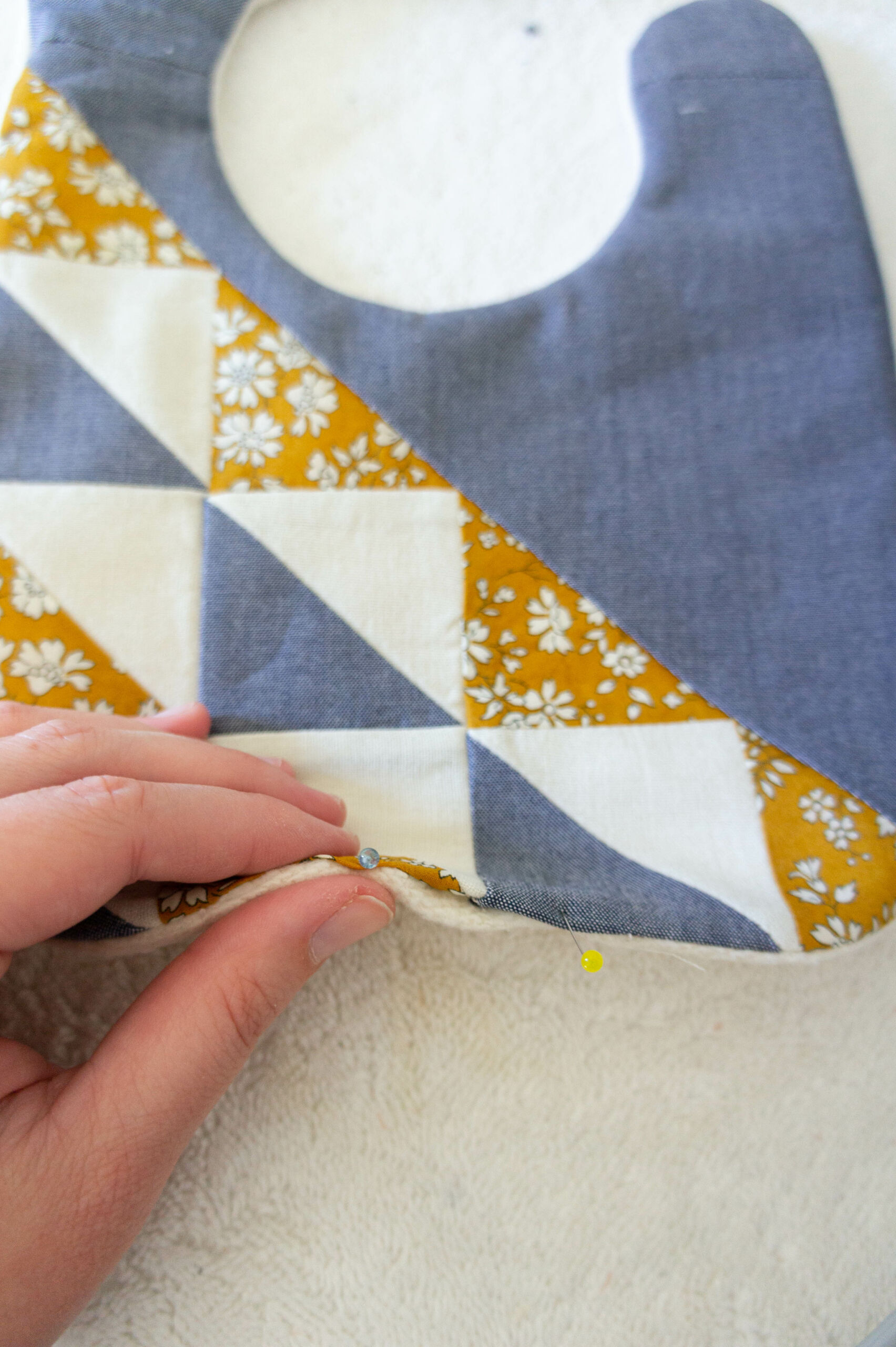 This fast and simple quilted baby bib tutorial uses the Fly Away pattern and fabric scraps to make something beautiful! suzyquilts.com #babybib #sewingtutorial