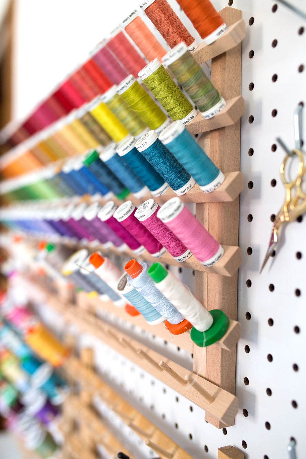 6 Tips for Mindful Making: An organization rack full of spools of rainbow colored thread. #quilting suzyquilts.com