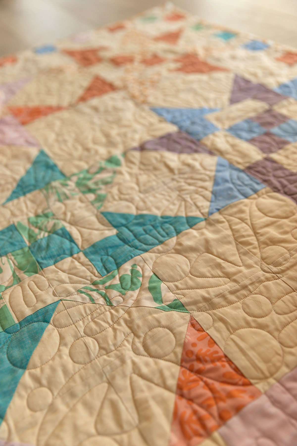 A Fat Quarter Stars quilt pattern by Suzy Quilts with a neutral background and orange, green, and purple stars. #Quilting #SewingDIY suzyquilts.com A Fat Quarter Stars quilt pattern by Suzy Quilts with a neutral background and orange, green, and purple stars. #Quilting #SewingDIY suzyquilts.com