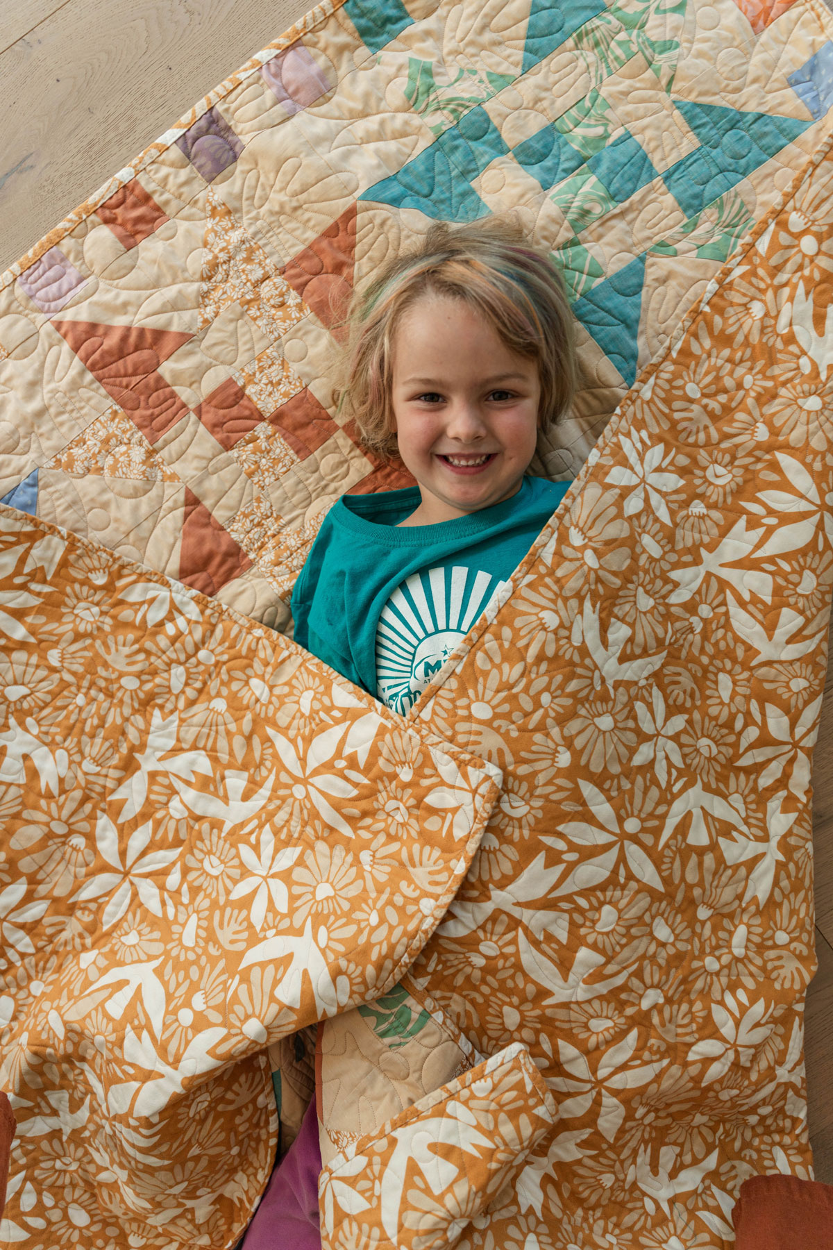A Fat Quarter Stars quilt pattern by Suzy Quilts with a neutral background and orange, green, and purple stars. #Quilting #SewingDIY suzyquilts.com A Fat Quarter Stars quilt pattern by Suzy Quilts with a neutral background and orange, green, and purple stars. #Quilting #SewingDIY suzyquilts.com