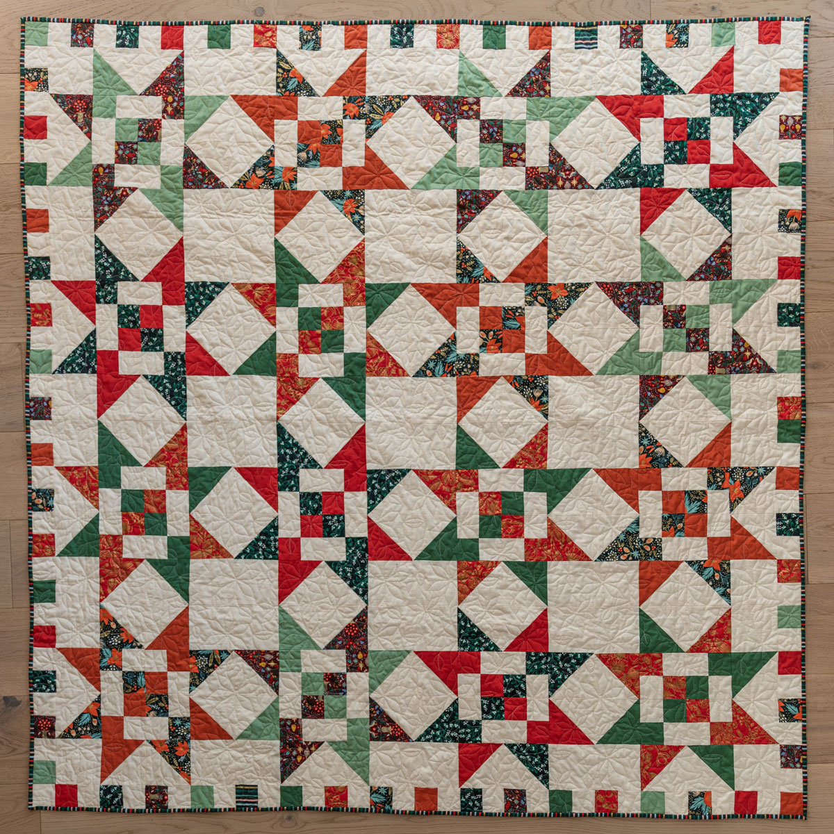 A Fat Quarter Stars quilt pattern by Suzy Quilts with a white background and red and green stars. #Quilting #SewingDIY suzyquilts.com A Fat Quarter Stars quilt pattern by Suzy Quilts with a white background and red and green stars. #Quilting #SewingDIY suzyquilts.com