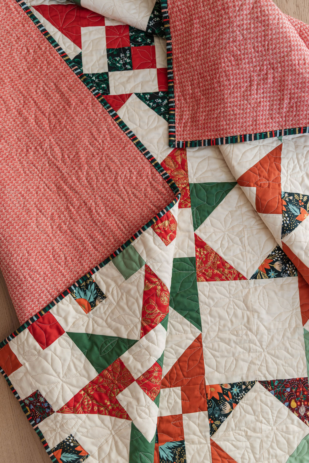 A Fat Quarter Stars quilt pattern by Suzy Quilts with a white background and red and green stars. #Quilting #SewingDIY suzyquilts.com A Fat Quarter Stars quilt pattern by Suzy Quilts with a white background and red and green stars. #Quilting #SewingDIY suzyquilts.com