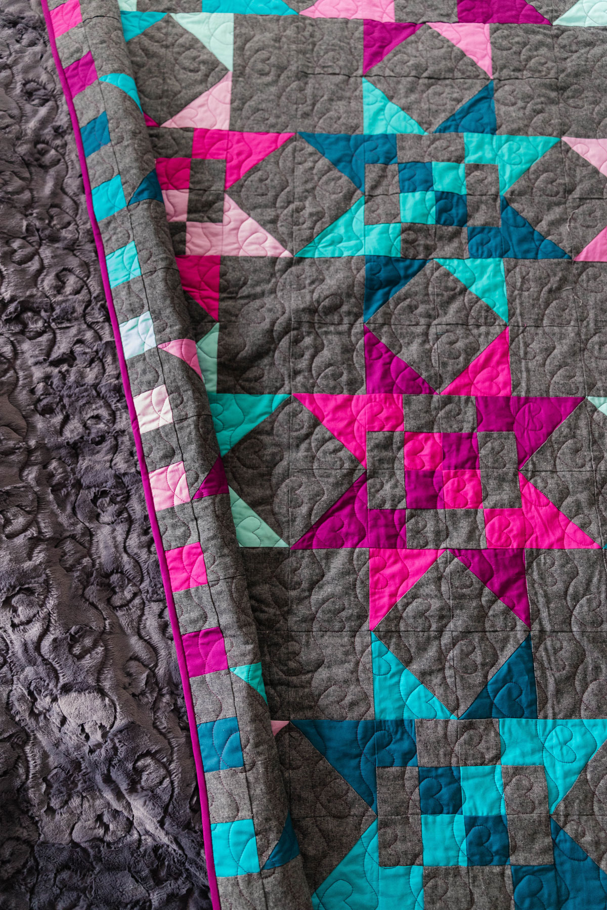 A Fat Quarter Stars quilt made using teal and magenta stars with a dark background. #Quilting #SewingDIY suzyquilts.com A Fat Quarter Stars quilt made using teal and magenta stars with a dark background. #Quilting #SewingDIY suzyquilts.com