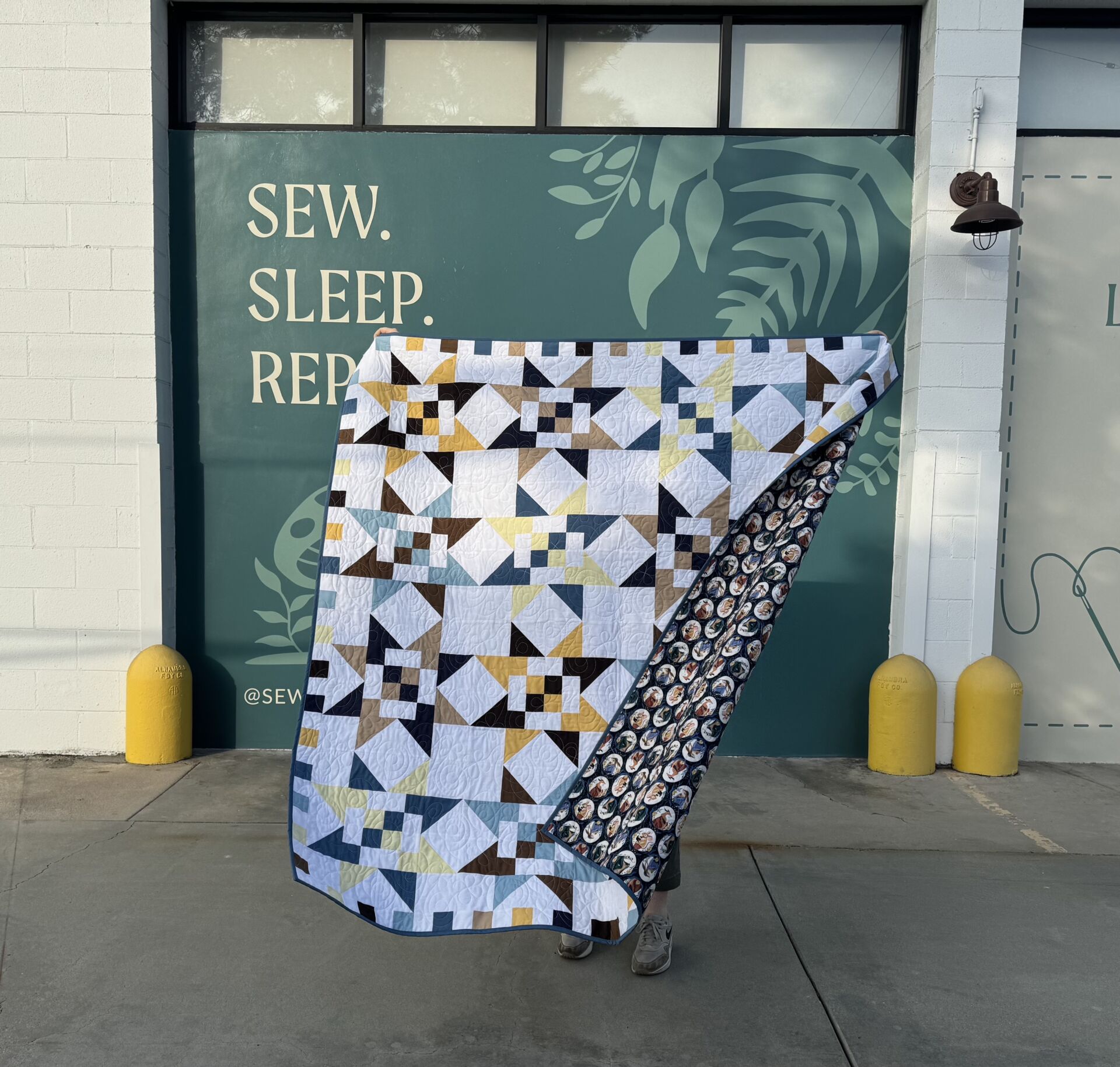 A Fat Quarter Stars quilt mockup with a white background and blue, yellow, and brown stars. #Quilting #SewingDIY suzyquilts.com A Fat Quarter Stars quilt mockup with a white background and blue, yellow, and brown stars. #Quilting #SewingDIY suzyquilts.com