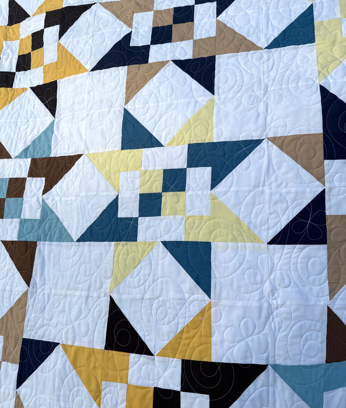 A Fat Quarter Stars quilt mockup with a white background and blue, yellow, and brown stars. #Quilting #SewingDIY suzyquilts.com A Fat Quarter Stars quilt mockup with a white background and blue, yellow, and brown stars. #Quilting #SewingDIY suzyquilts.com